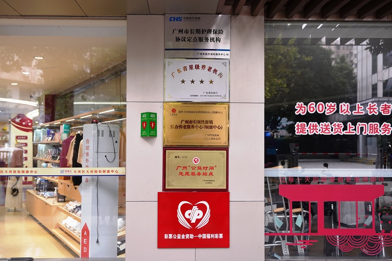配图2：颐康中心门口的墙上，“彩票公益金资助—中国福利彩票”的红色标识牌格外醒目（羊城晚报摄）.jpg