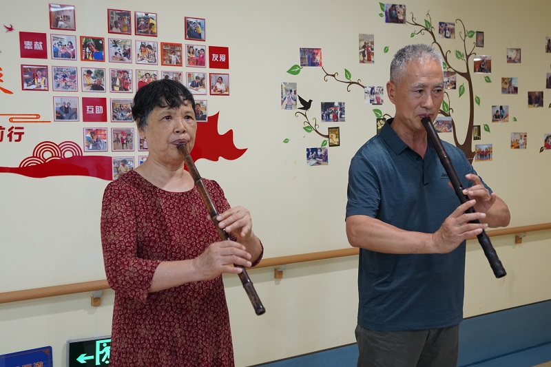 配图3：长者们展示吹洞箫（羊城晚报摄）.jpg